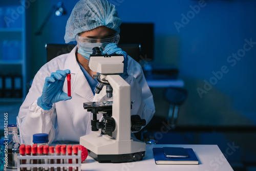 Konstfotografi Medical or research scientist or doctor using looking at a test tube of clear solution in a lab or laboratory