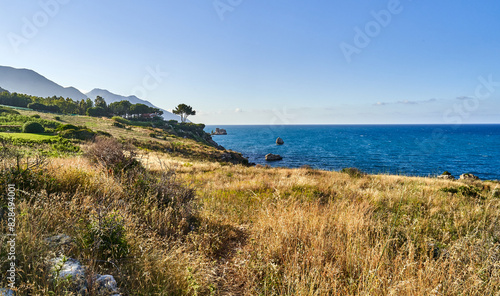 Sicily coast by house with mountains in the distance © Wirestock