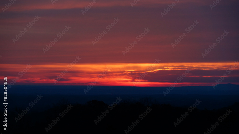 the setting sun over a mountain range from the air at sunset the setting sun over a mountain range from the air at sunset