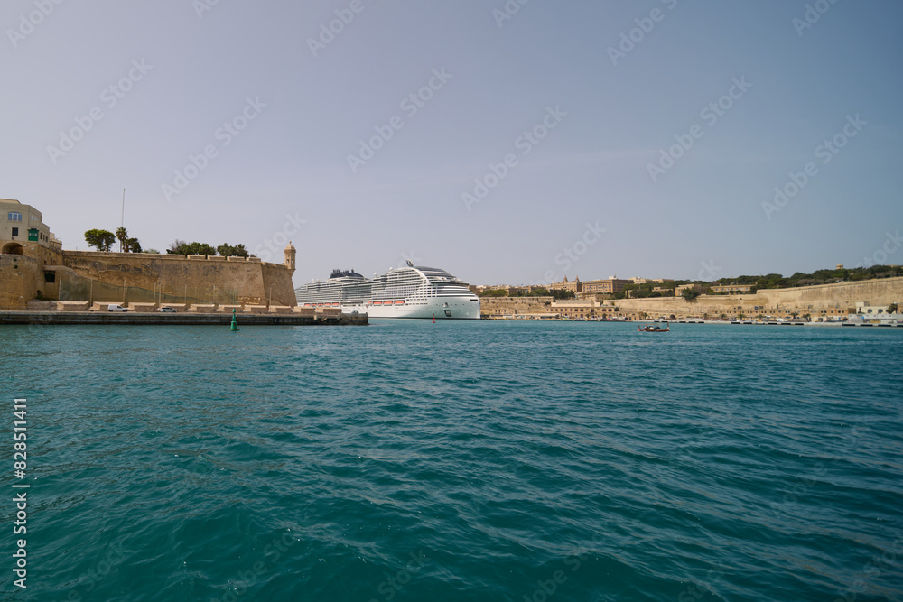 a body of water with several boats near a stone building a body of water with several boats near a stone building