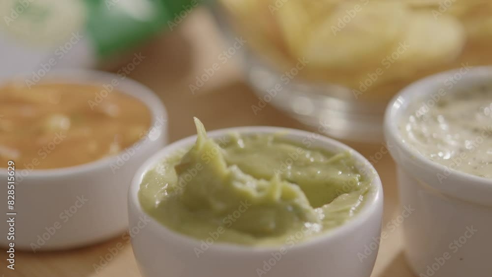 Close-up shot of a banana chip being dipped into a sauce. Close-up shot of a banana chip being dipped into a sauce.
