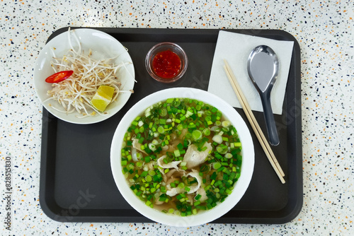Vietnamese pho soup and bean sprouts on a tray. Fast food restaurant.