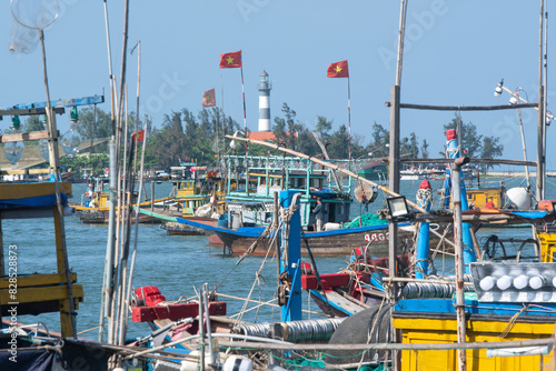 View of Cua Dai Lighthouse and Vietnamese fishing boats from Duy Hai village marina, Vietnam.