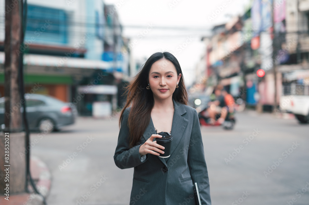 Beautiful Woman Going To Work With Coffee Walking Near Office Building. Business Woman Holding Cup Of Hot Drink In Hand On Her Way To Work On City Street. Beautiful Woman Going To Work With Coffee Walking Near Office Building. Business Woman Holding Cup Of Hot Drink In Hand On Her Way To Work On City Street.