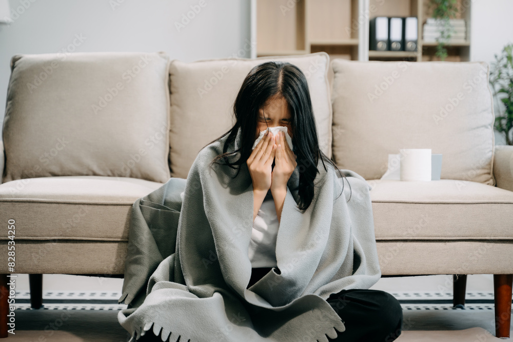 Young Asian woman suffering from flu symptoms, covered with a blanket on a sofa. Concept of illness, healthcare, Young Asian woman suffering from flu symptoms, covered with a blanket on a sofa. Concept of illness, healthcare,