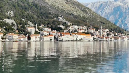 The Perast coast with sea and the church of saint Nicholas in front of the mountains of Perast town photo