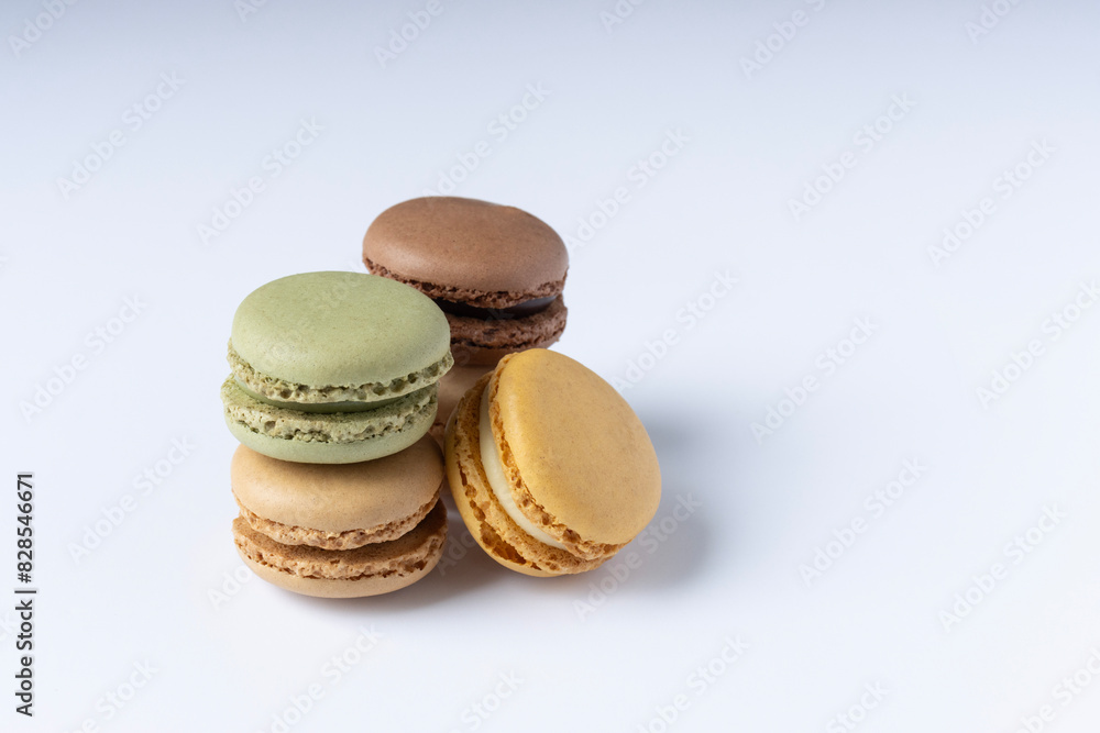 Macarons on a white background close-up. Orange green and brown macaroons. Space for text