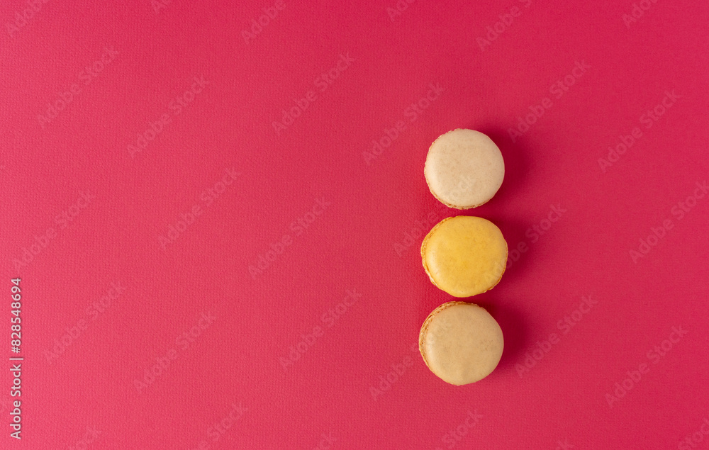Three macaroons on a red background. Dessert close-up with copy space. Top view Three macaroons on a red background. Dessert close-up with copy space. Top view