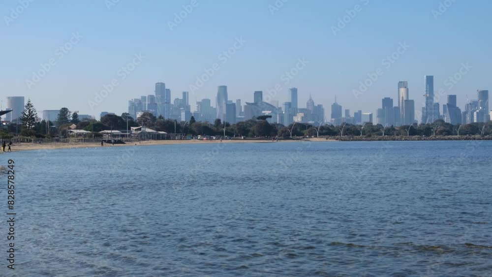 Beach and coastline at Port Melbourne with modern high-rise skyscraper buildings in the distance. Urban skyline over the sea. VIC Autralia. Beach and coastline at Port Melbourne with modern high-rise skyscraper buildings in the distance. Urban skyline over the sea. VIC Autralia.