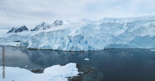 Global Warming and Climate Change - Giant glacier towers in Antarctica. Aerial drone view arctic nature winter landscape. Melting ice floes fjord in cold polar ocean. Global issue of melting icebergs