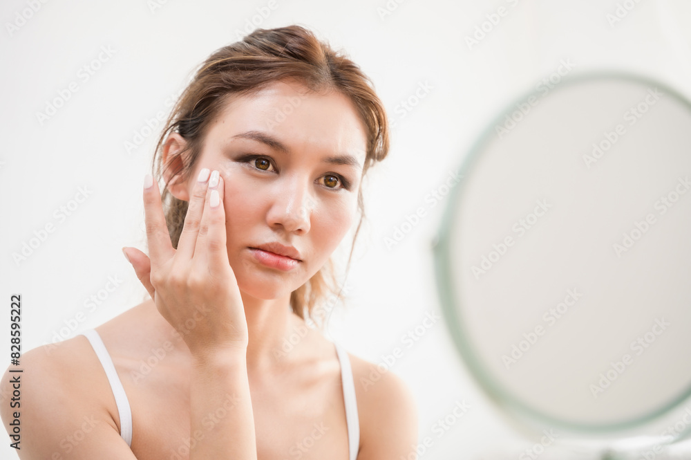 Young beautiful Asian woman checking her facial skin in mirror feeling worried about freckles wrinkles acne scar on face. Lady beauty self care skincare problem solution product advertising concept. Young beautiful Asian woman checking her facial skin in mirror feeling worried about freckles wrinkles acne scar on face. Lady beauty self care skincare problem solution product advertising concept.