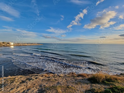 Beautiful horizon view on the mediterranean sea, blue sky, clouds, coastline, waves