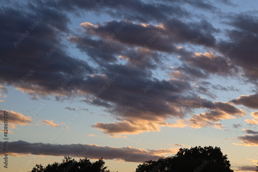scattered clouds dark below and white above at sunset scattered clouds dark below and white above at sunset