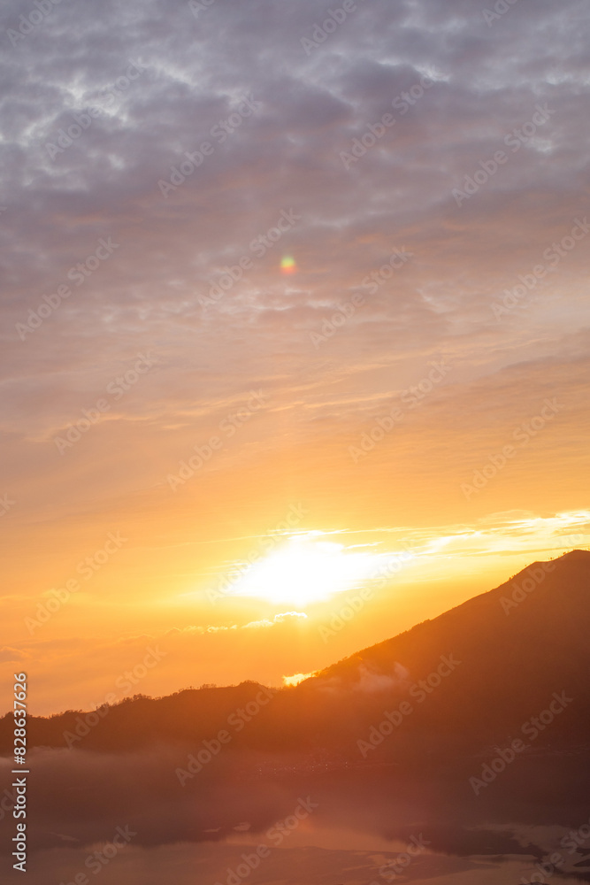 Sunrise over Mount Batur with a golden sky and silhouetted mountains. Travel Sunrise over Mount Batur with a golden sky and silhouetted mountains. Travel