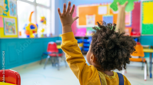 ): A young pupil in a vividly colored classroom raising their hand to respond to a quz.j
