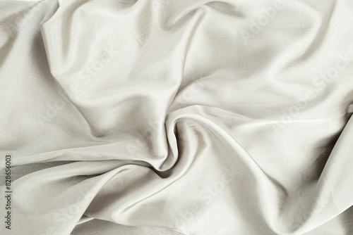 Gary color satin cloth arranged in the shape of a swirl, abstract textured backdrop photo