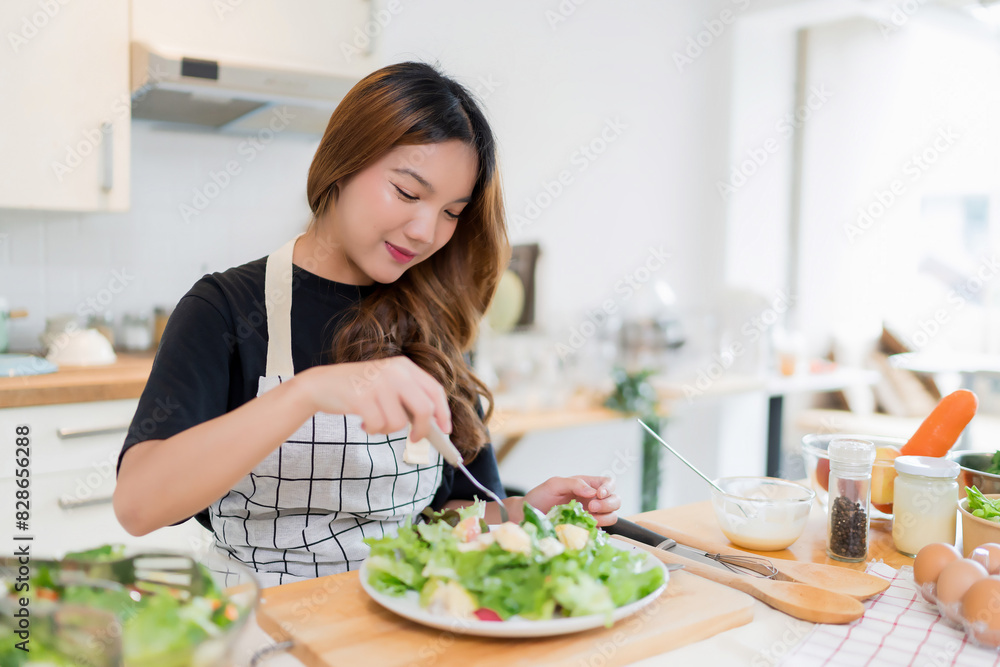 Young asian woman enjoying to eating vegetables salad after mixing fresh vegetables salad with dressing in bowl and cooking healthy breakfast food in modern kitchen with healthy lifestyle at home Young asian woman enjoying to eating vegetables salad after mixing fresh vegetables salad with dressing in bowl and cooking healthy breakfast food in modern kitchen with healthy lifestyle at home