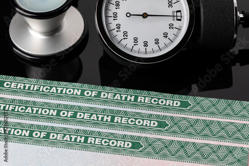 Blood pressure cuff and death certificate record. Hypertension, high blood pressure and heart health concept.