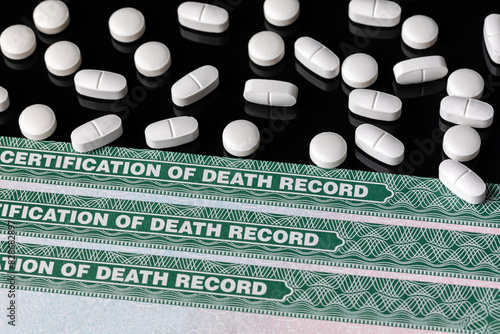 Prescription pills with death certificate record. Painkiller addiction disorder, drug abuse, suicide, and opioid overdose concept