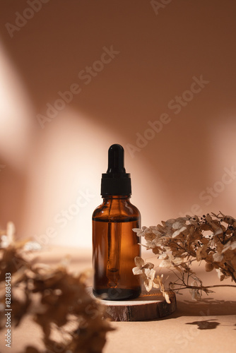 Dropper bottle on wooden podium with dry flowers on pastel beige background. Aesthetic, minimal beauty product packaging design.