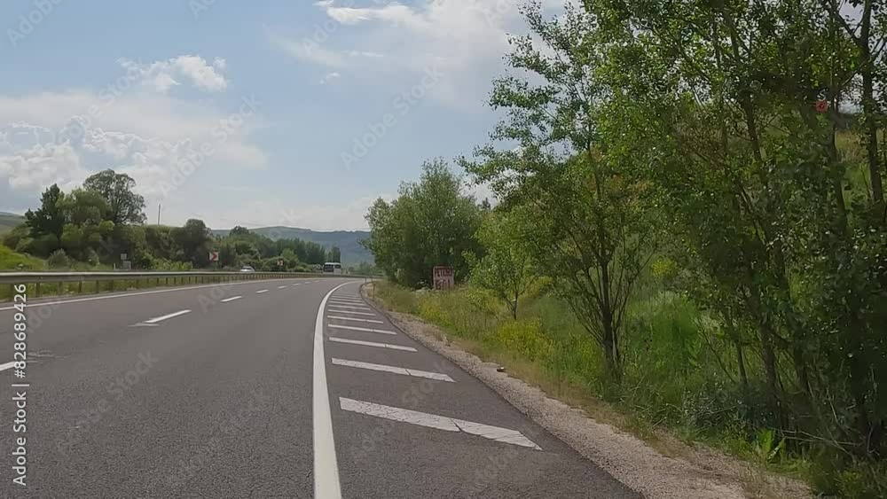 Road view on a summer day. Highways and landscape, palm trees and mountains, roadside and white road line markings. Road view on a summer day. Highways and landscape, palm trees and mountains, roadside and white road line markings.