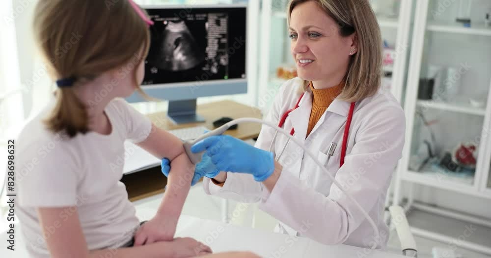 Child patient with orthopedic doctor in office. Ultrasound of elbow joint in children Child patient with orthopedic doctor in office. Ultrasound of elbow joint in children
