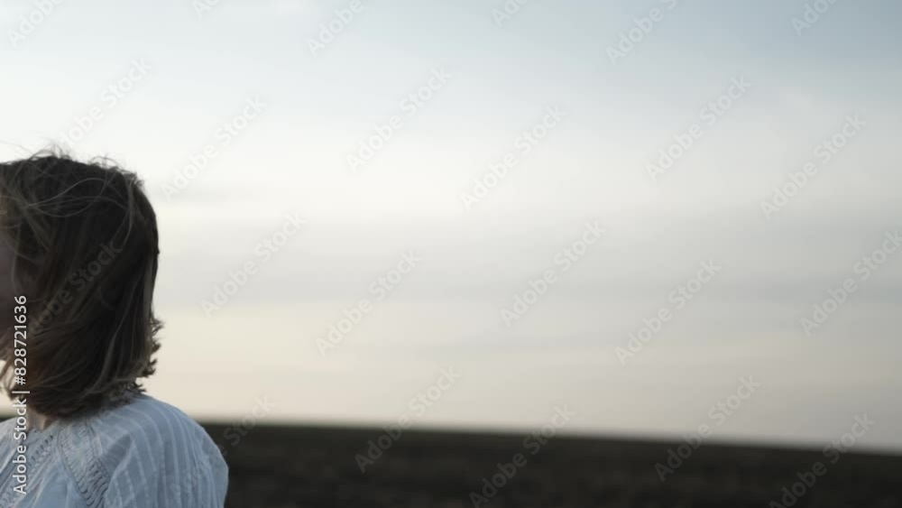 Beautiful girl walking on the green field. Girl at sunset on the wheat field Beautiful girl walking on the green field. Girl at sunset on the wheat field
