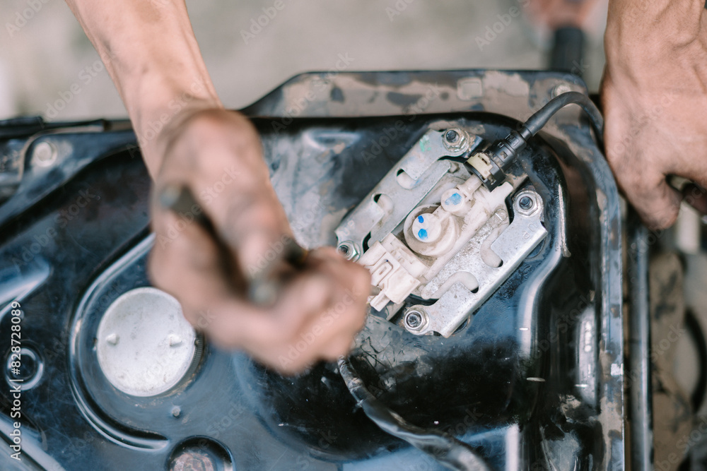 A motorcycle mechanic inspecting a damaged engine A motorcycle mechanic inspecting a damaged engine