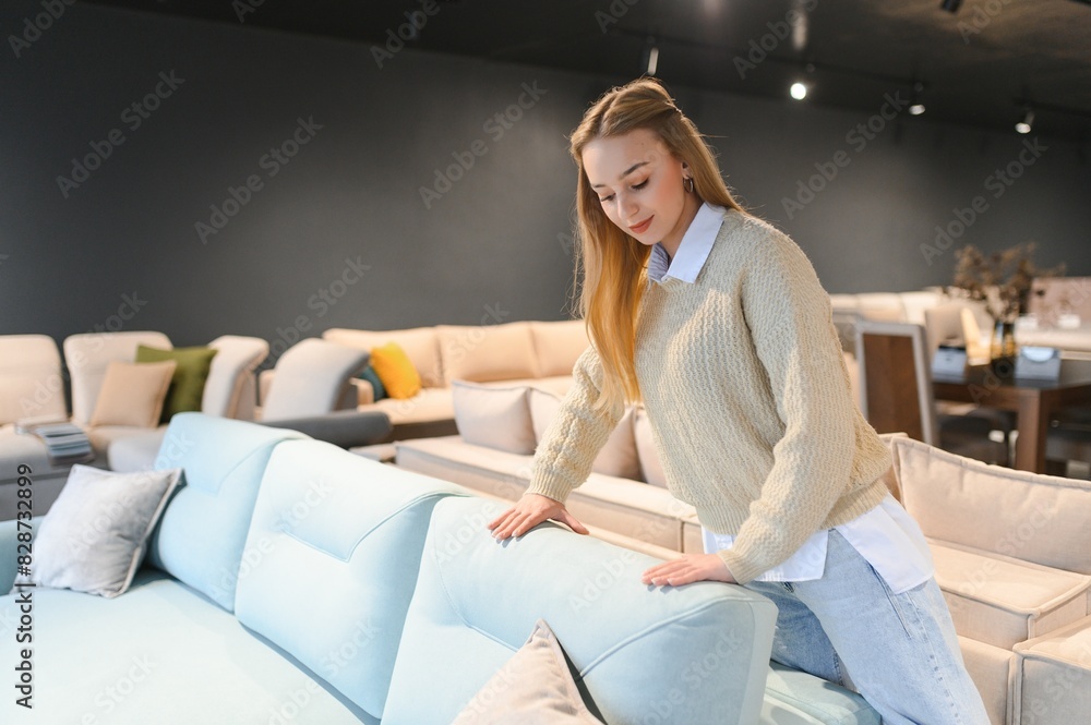 Portrait of young cheerful woman testing sofa in furniture store Portrait of young cheerful woman testing sofa in furniture store
