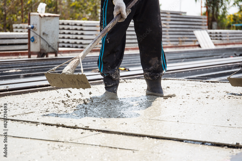 Workers pouring concrete into reenforced metal structure block. Workers pouring concrete into reenforced metal structure block.