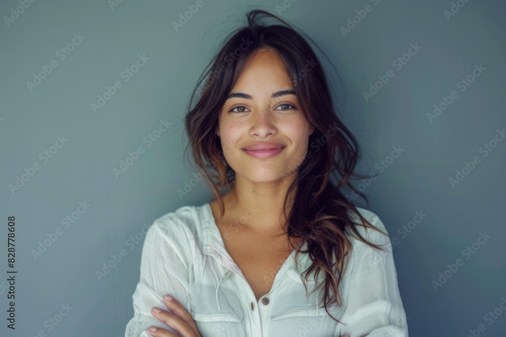 Smiling Latin woman with crossed arms on grey background. Smiling Latin woman with crossed arms on grey background.