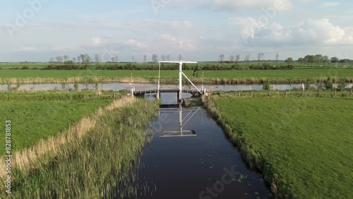 Aerial View: Dokkumer Ee River with Picturesque Bridge in Friesland Farmland, Netherlands photo
