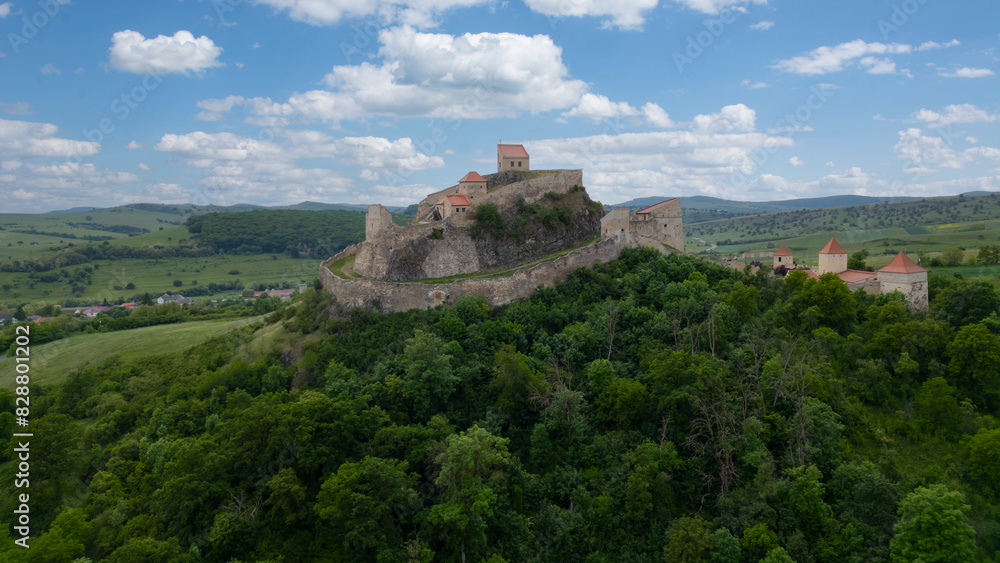Rupea fortress in Romania. Amazing aerial view with blue sky with clouds. Trips to Transylvania. Medieval saxon landmark. Rupea fortress in Romania. Amazing aerial view with blue sky with clouds. Trips to Transylvania. Medieval saxon landmark.