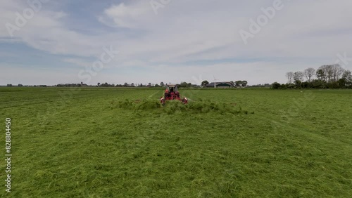 Harvesting Season: Aerial Shot of Tractor Shaking Grass on Farmland (ID: 828804450)
