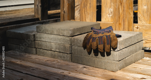Cement construction blocks and work gloves on house deck