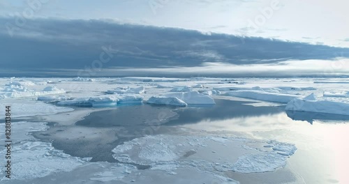 Antarctica winter landscape frozen ocean panorama. Snow covered ice floes and icebergs drifting frigid waters under blue sky reflection. South Pole seascape aerial view. Explore Antarctic wildlife