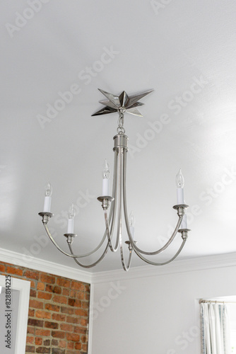 Star-Topped Silver Chandelier in A Room with Exposed Brick Wall