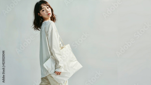 Asian Woman Posing with Tote Bag Against White Background