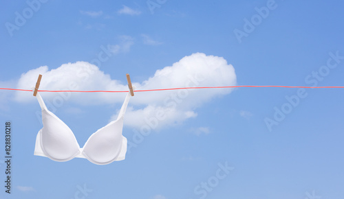 Weisser Büstenhalter auf einer Wäscheleine vor blauem Himmel
