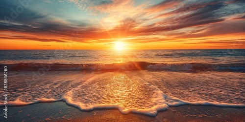 A breathtaking sunset over the ocean with vibrant colors and gentle waves washing onto the sandy beach