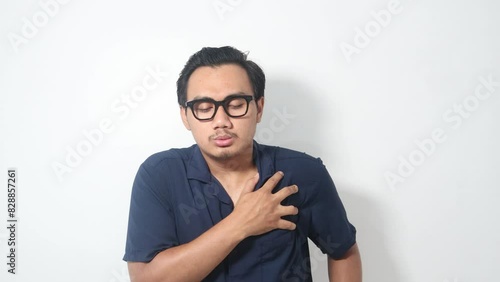 Footage of Asian man touching chest feeling sudden acute pain in heart, risk of stroke or heart attack, healthcare problem. Indoor studio shot isolated on white background