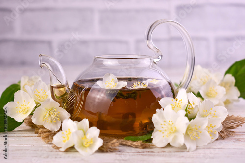 Fragrant tea with jasmine flowers in a teapot.
