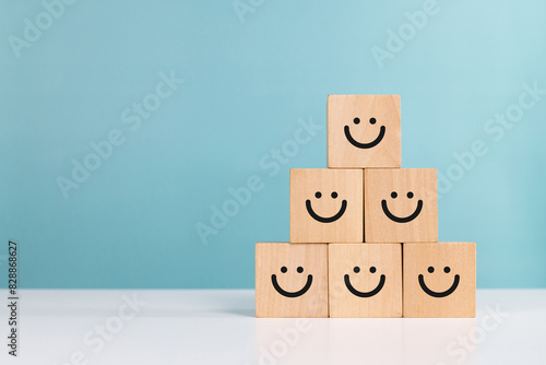 Service rating,winner,satisfaction and positive feedback concept. Smiling face emoticon on wooden cube indicates good service with copy space