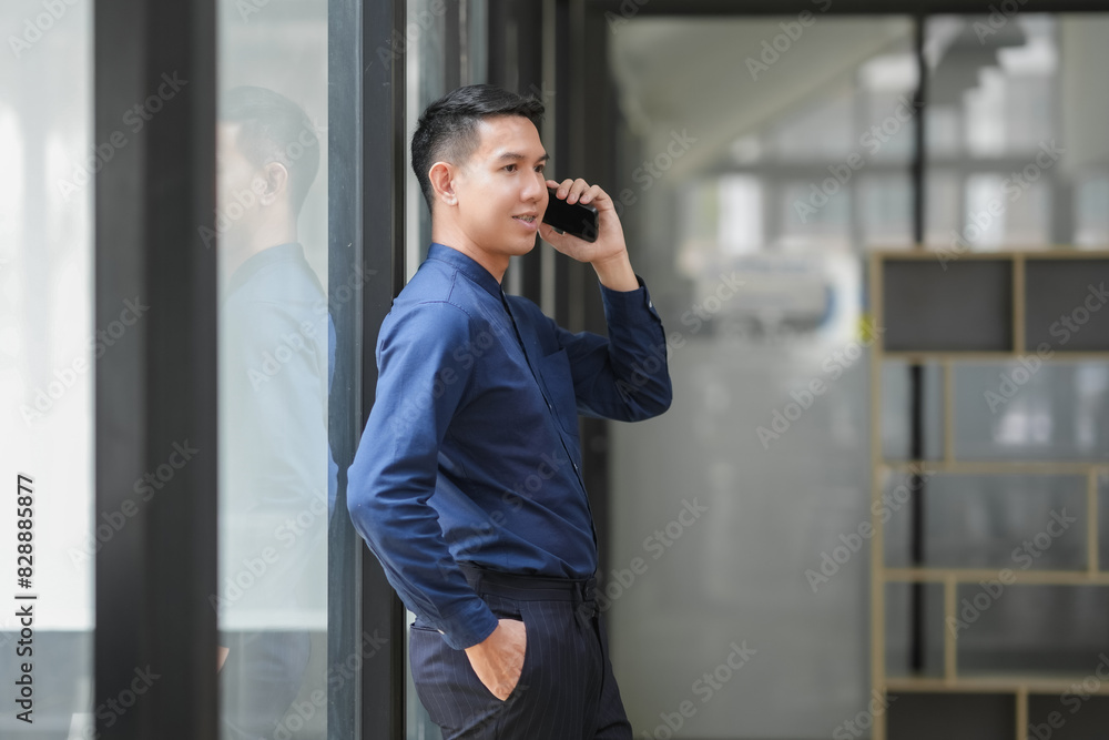 Businessman in blue shirt talking on phone outside office building, representing communication and professional attire. Businessman in blue shirt talking on phone outside office building, representing communication and professional attire.