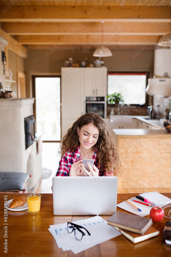 A beautiful university student is writing her thesis on a laptop, sitting at home on the couch. A beautiful university student is writing her thesis on a laptop, sitting at home on the couch.