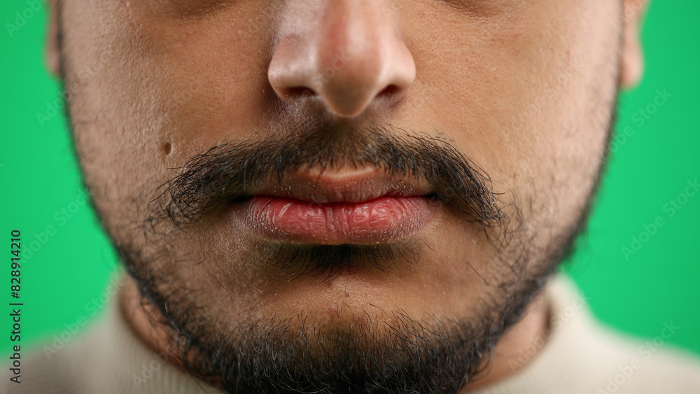 Fototapeta premium Man's mouth, close-up, on a green background