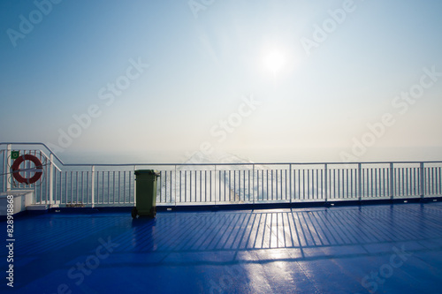 A life preserver and a trach can on the aft deck of a passenger ferry.. photo