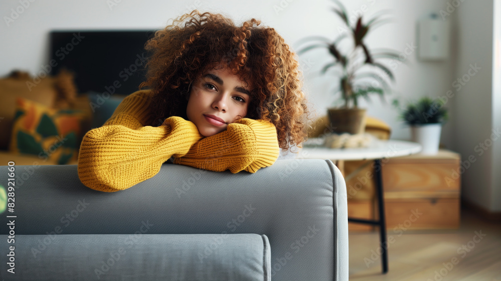 Curly haired brunette woman relaxing on the couch at home. Curly haired brunette woman relaxing on the couch at home.