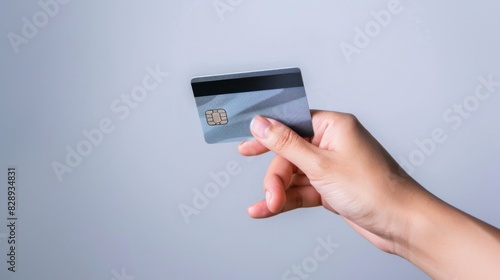 hand hold a credit card with neutral background, only hand and credit card