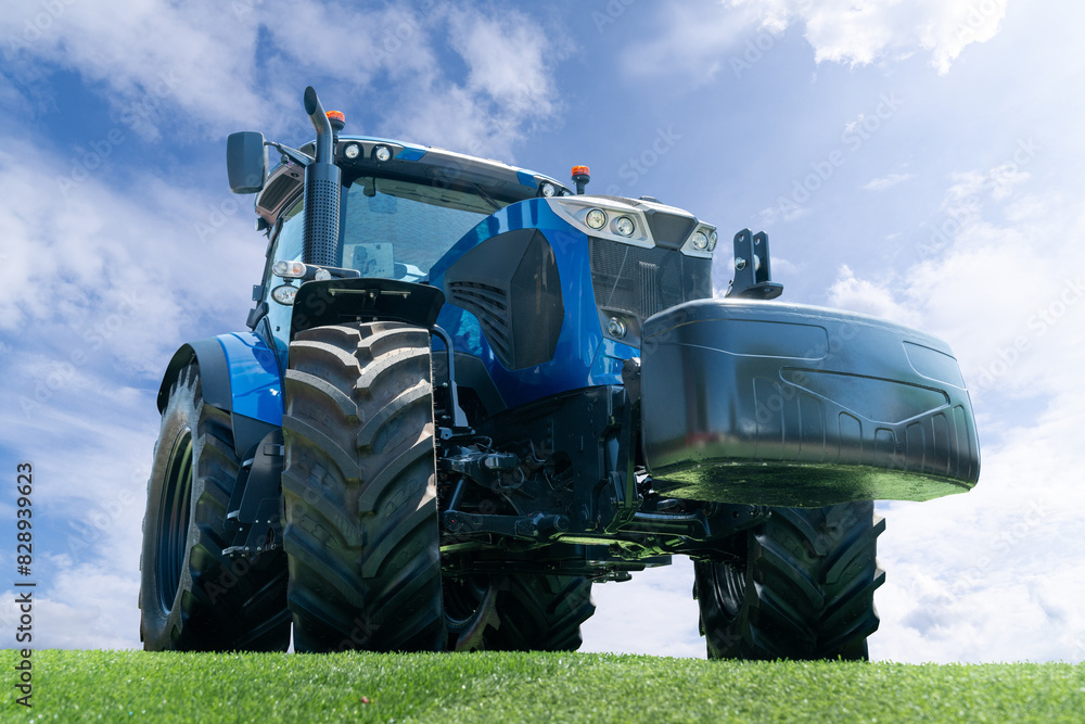 Fototapeta premium Modern blue agricultural tractor on a background of blue sky.
